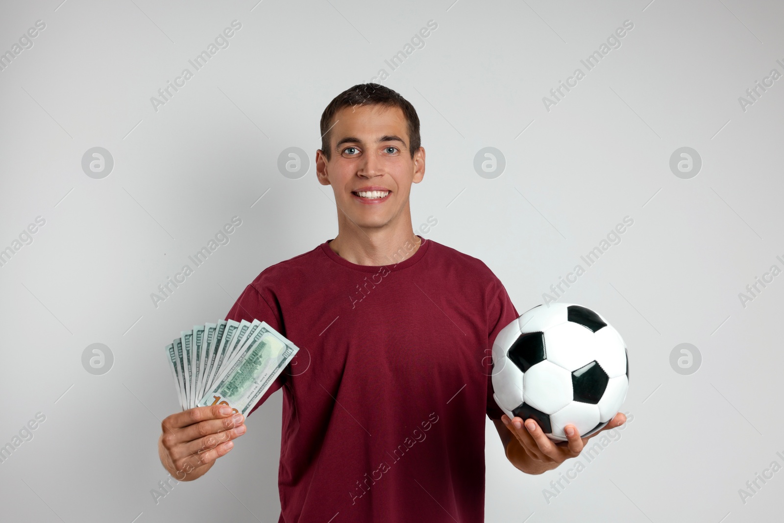 Photo of Happy man with money and soccer ball on white background