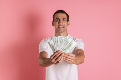 Photo of Happy man with money on pink background