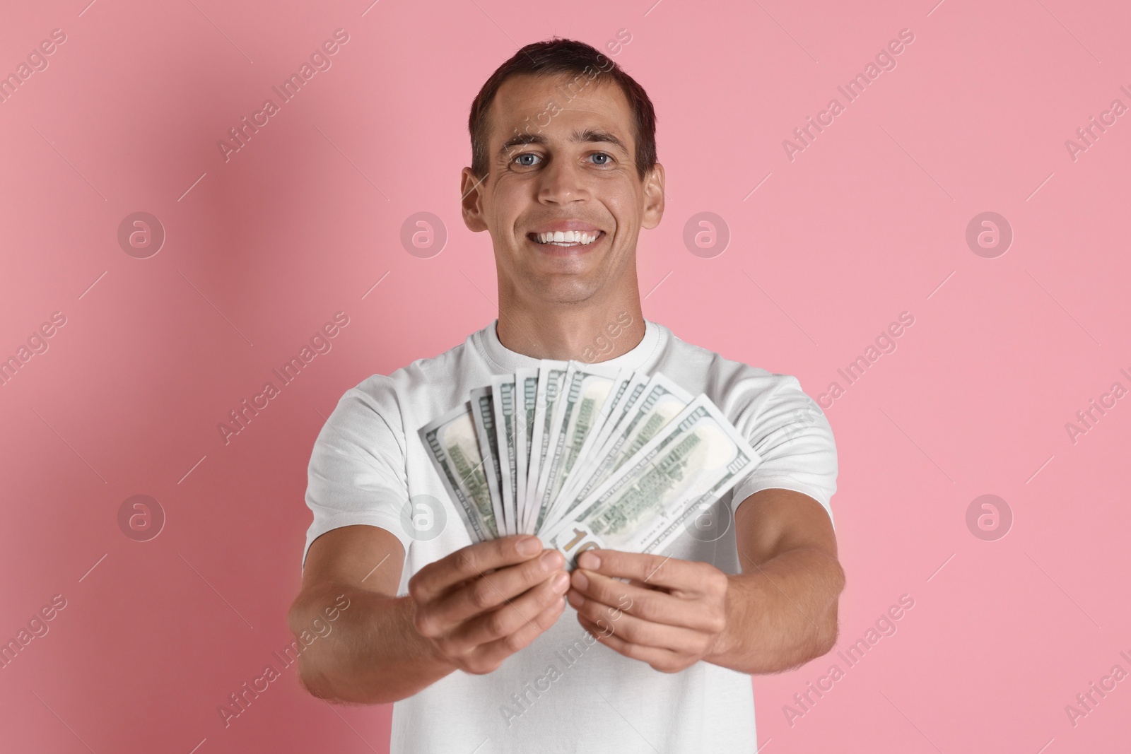 Photo of Happy man with money on pink background