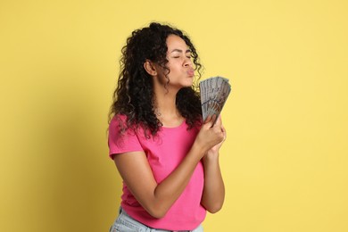 Woman with dollar banknotes on yellow background