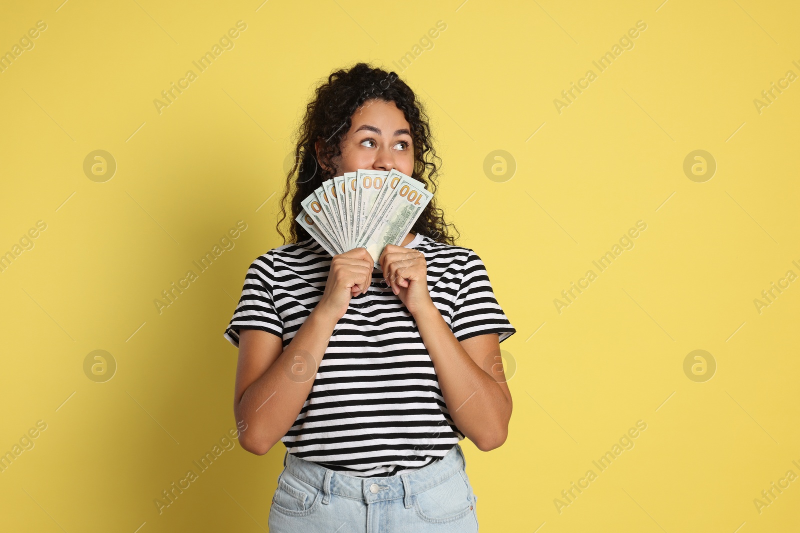 Photo of Woman with dollar banknotes on yellow background