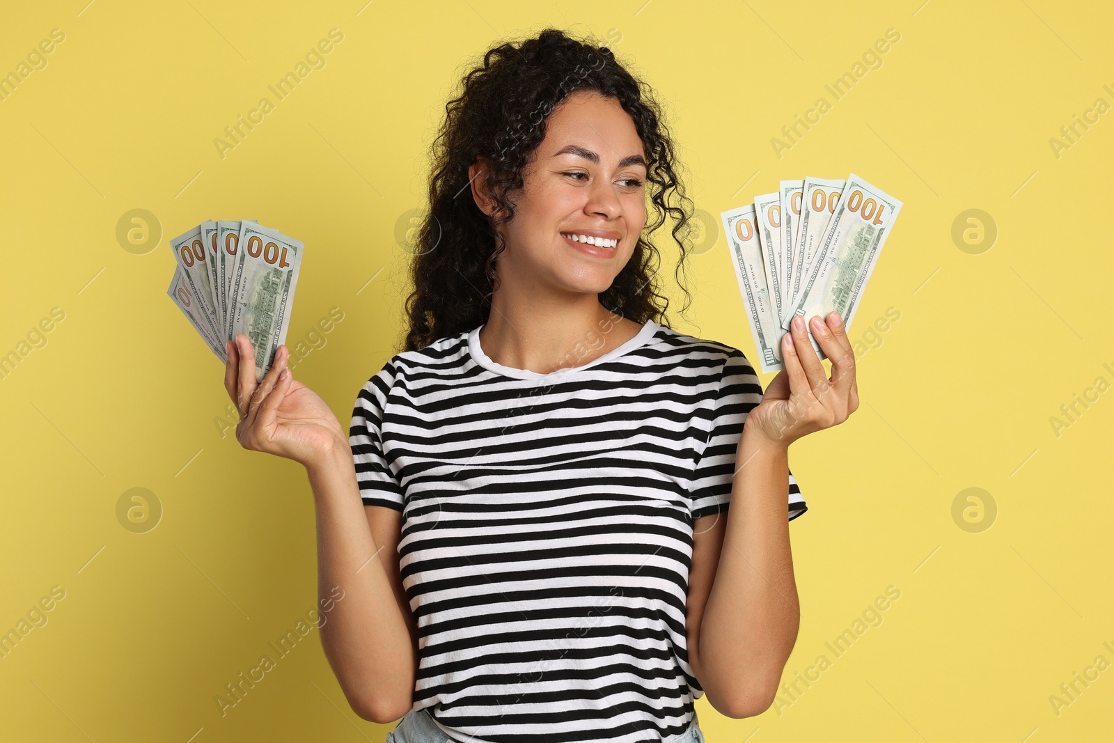 Photo of Happy woman with dollar banknotes on yellow background