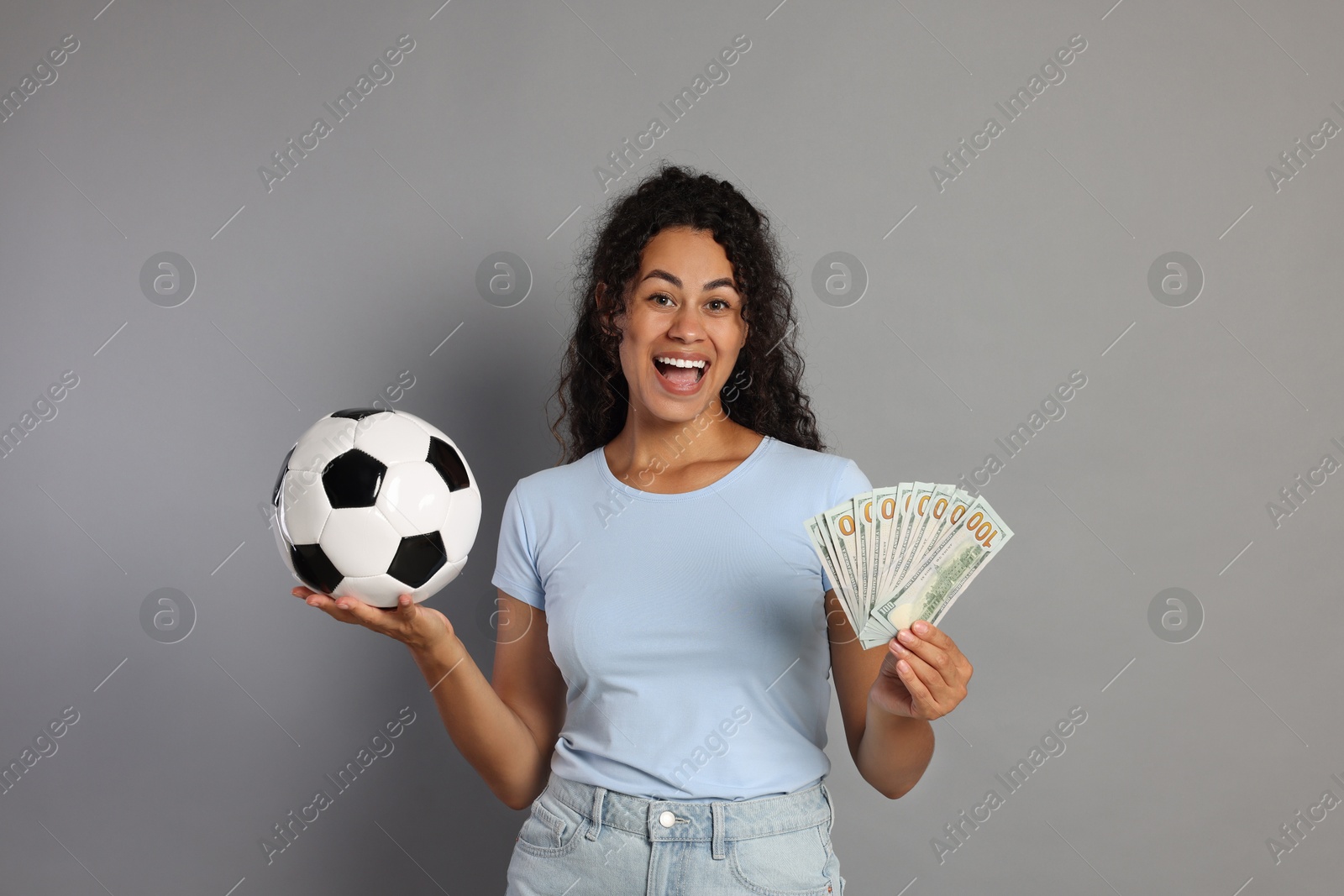 Photo of Happy woman with money and soccer ball on grey background