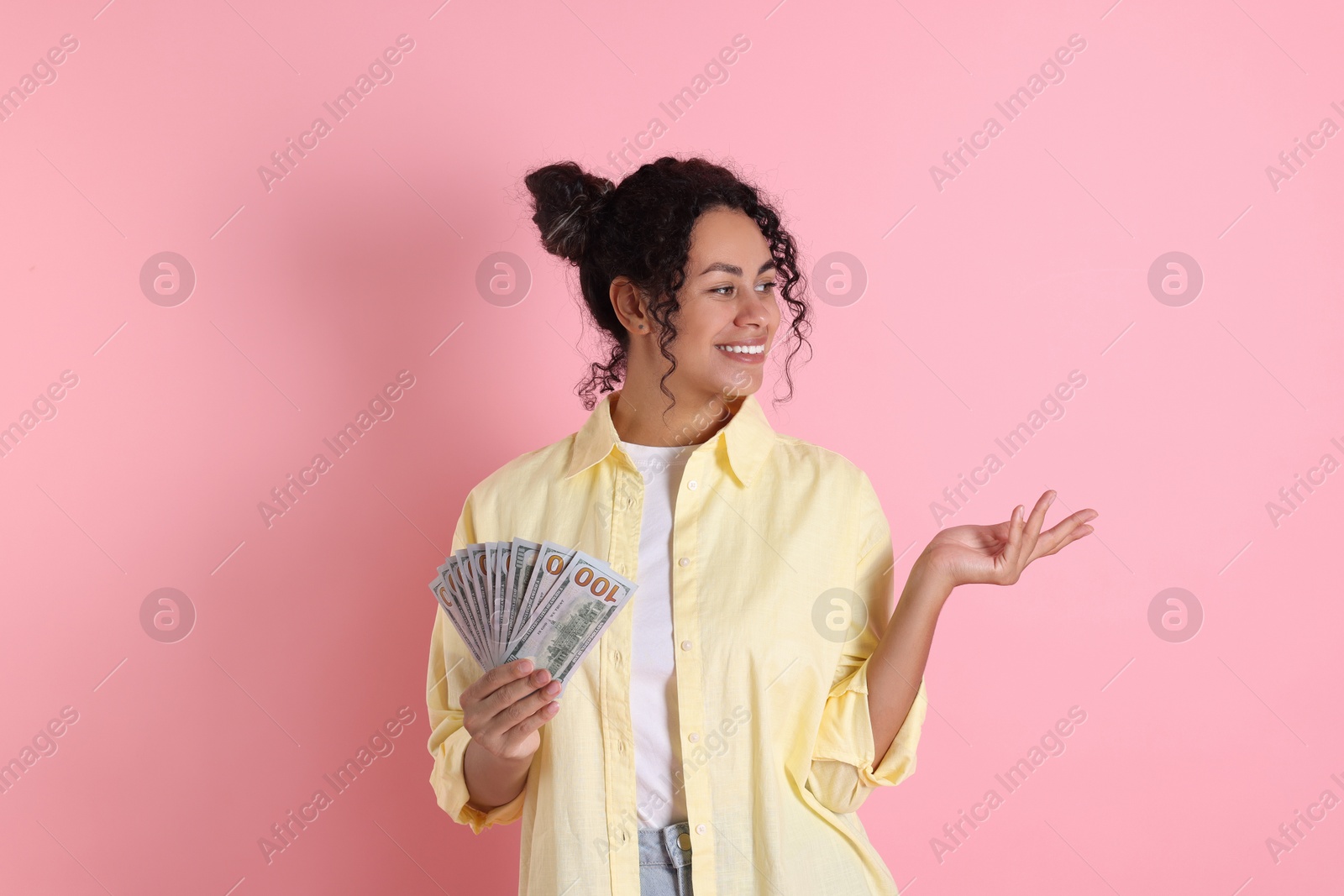 Photo of Happy woman with dollar banknotes on pink background