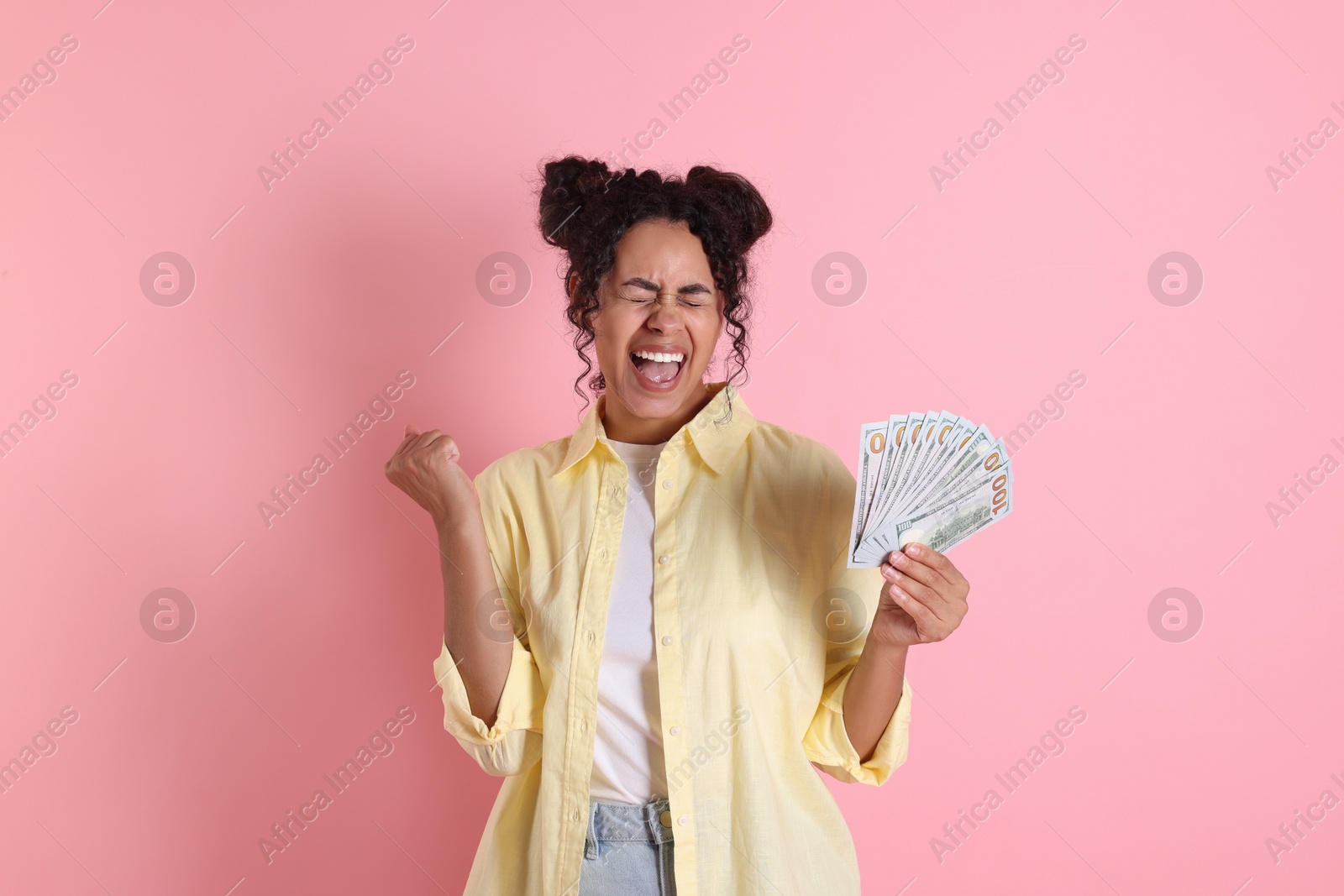 Photo of Happy woman with dollar banknotes on pink background