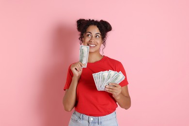 Photo of Happy woman with dollar banknotes on pink background