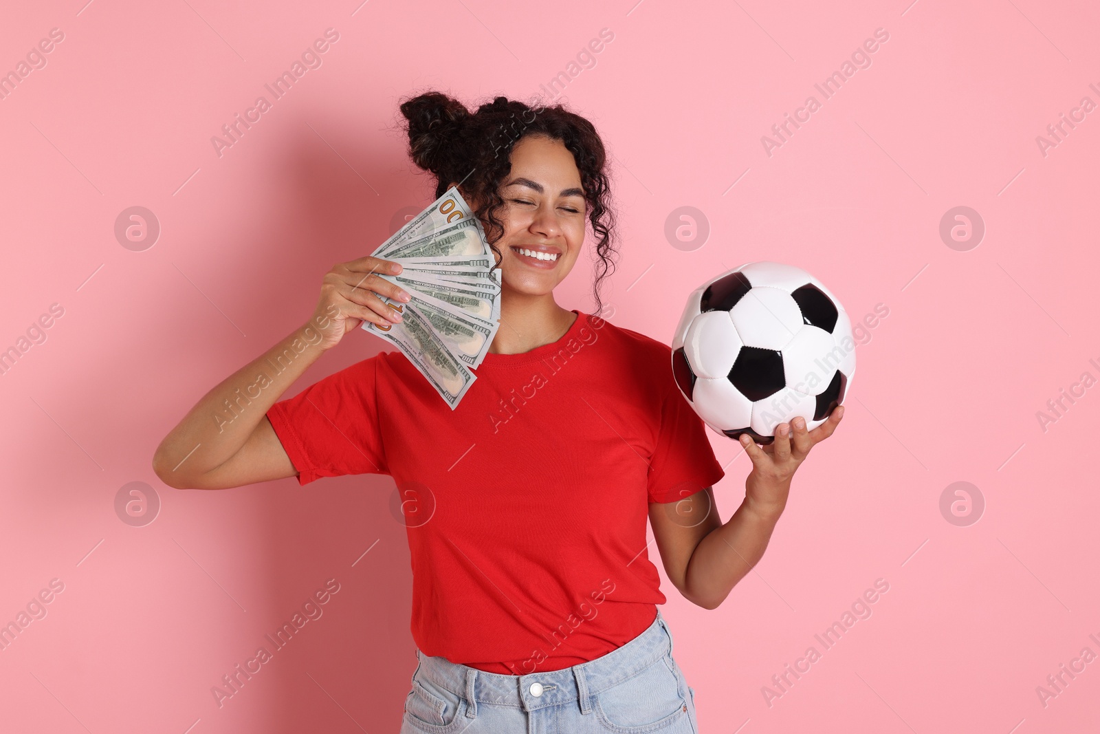 Photo of Happy woman with money and soccer ball on pink background