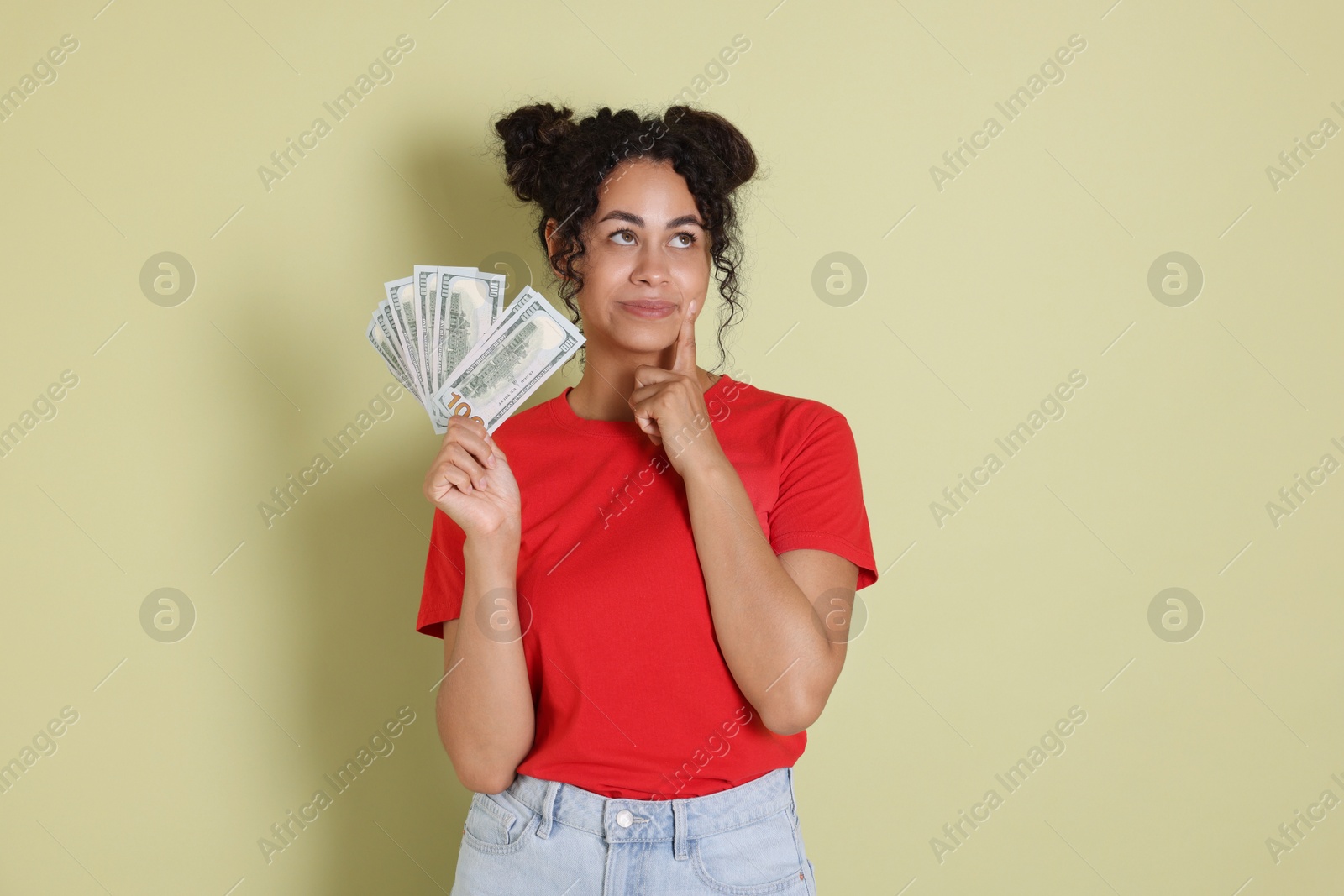 Photo of Woman with dollar banknotes on pale green background