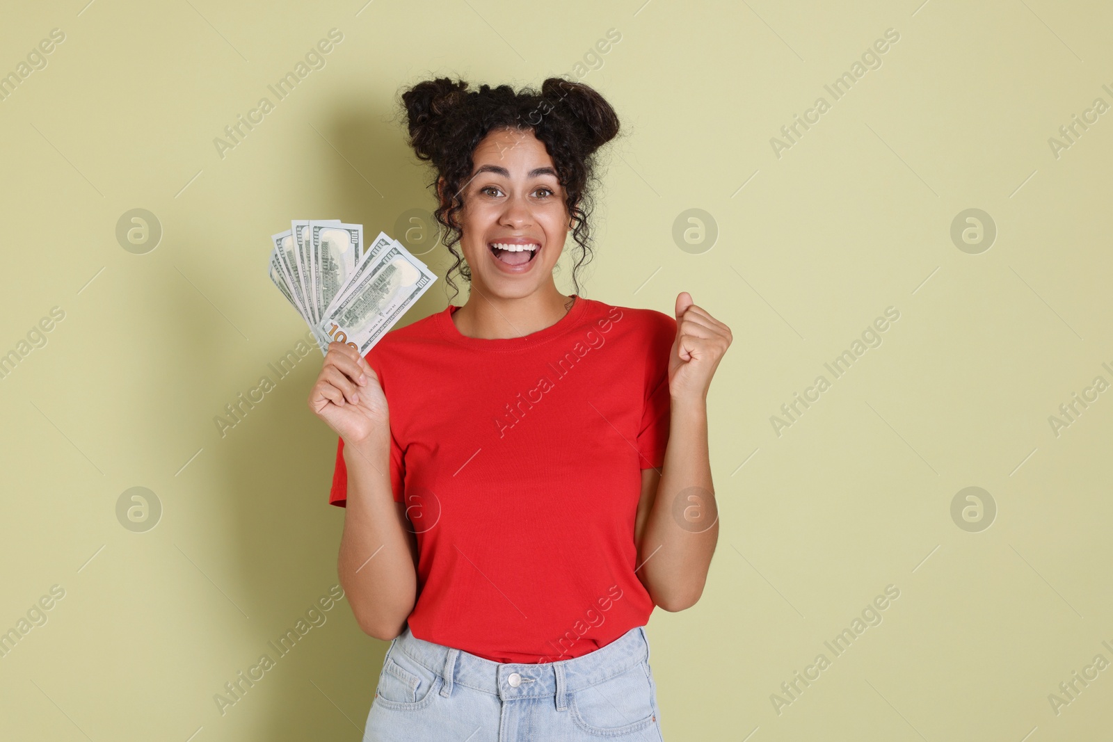 Photo of Happy woman with dollar banknotes on pale green background