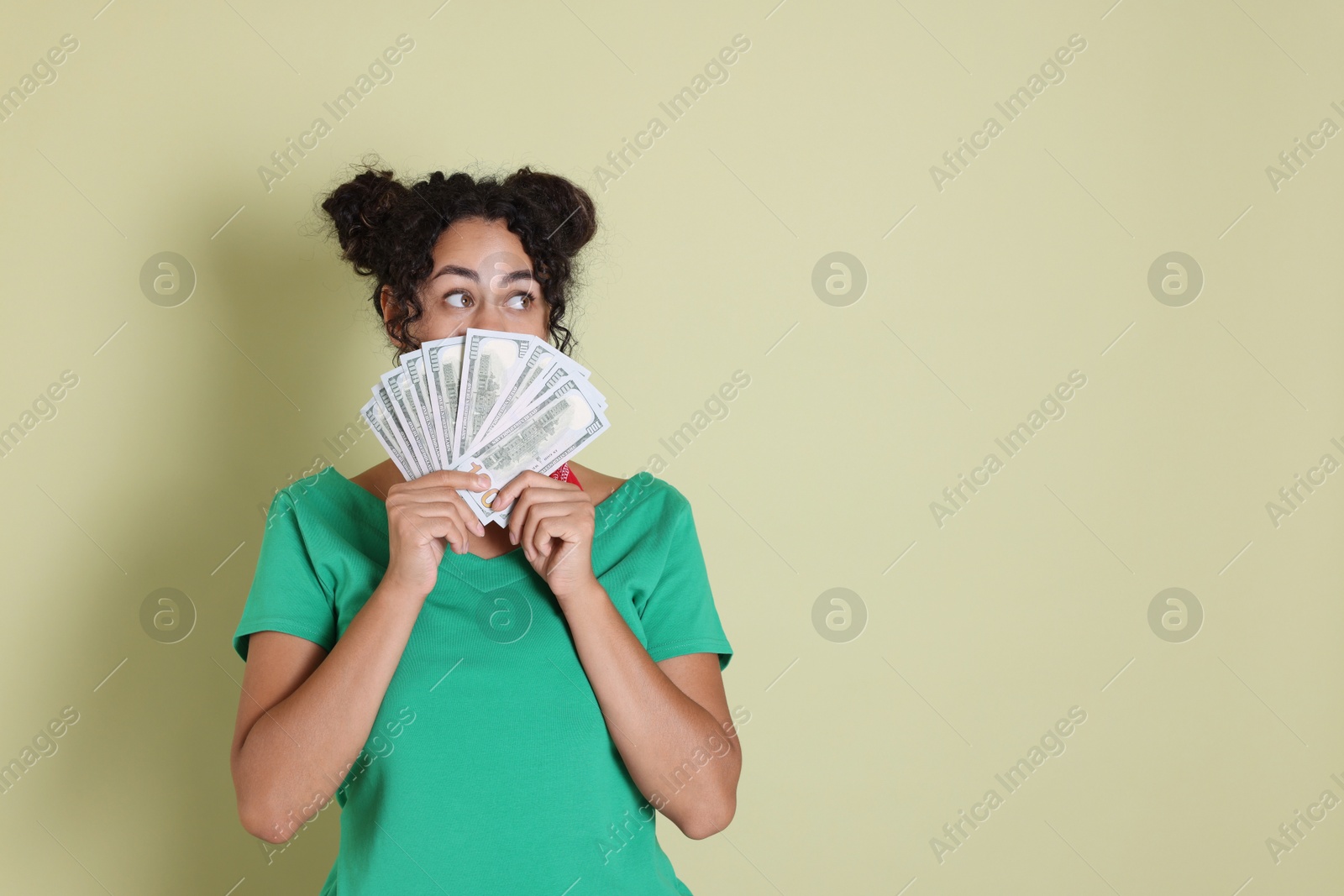 Photo of Woman with dollar banknotes on pale green background, space for text