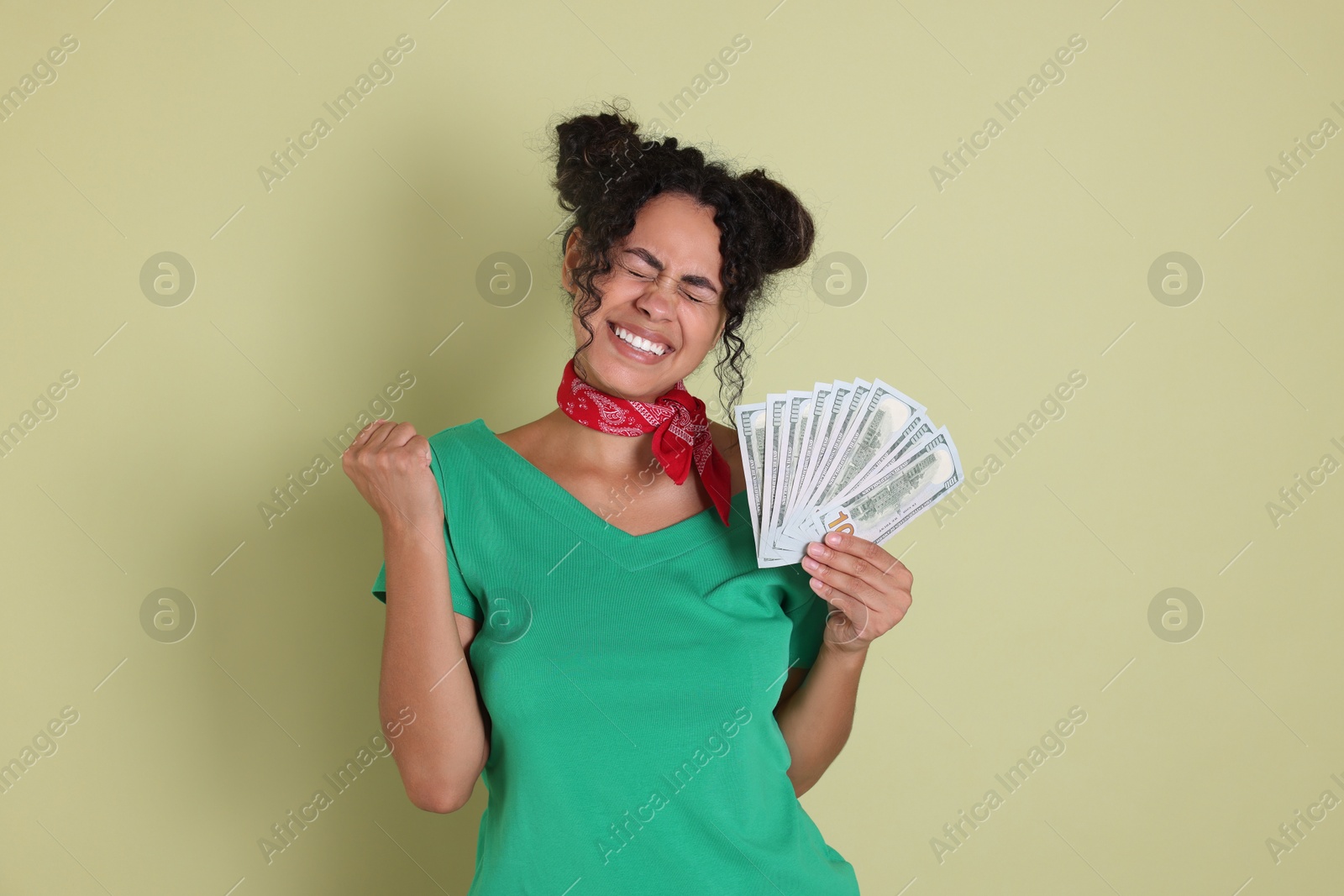 Photo of Happy woman with dollar banknotes on pale green background