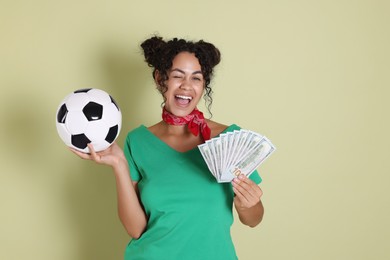 Photo of Happy woman with money and soccer ball on pale green background