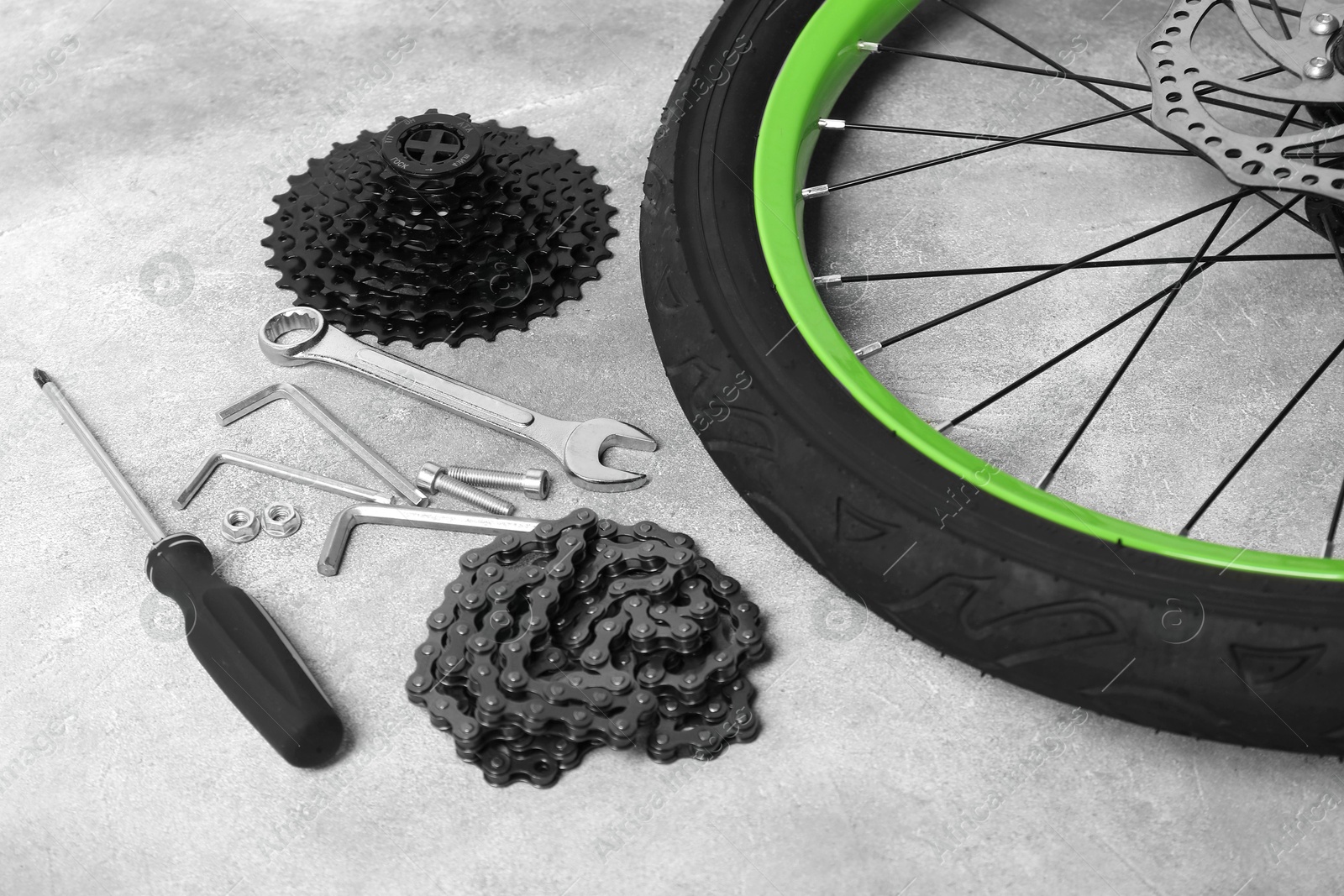 Photo of Parts of bicycle and tools on grey background, closeup