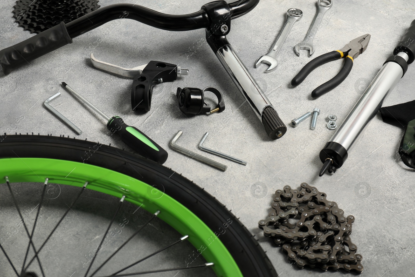 Photo of Parts of bicycle and tools on grey background, closeup