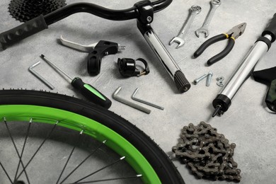 Photo of Parts of bicycle and tools on grey background, closeup