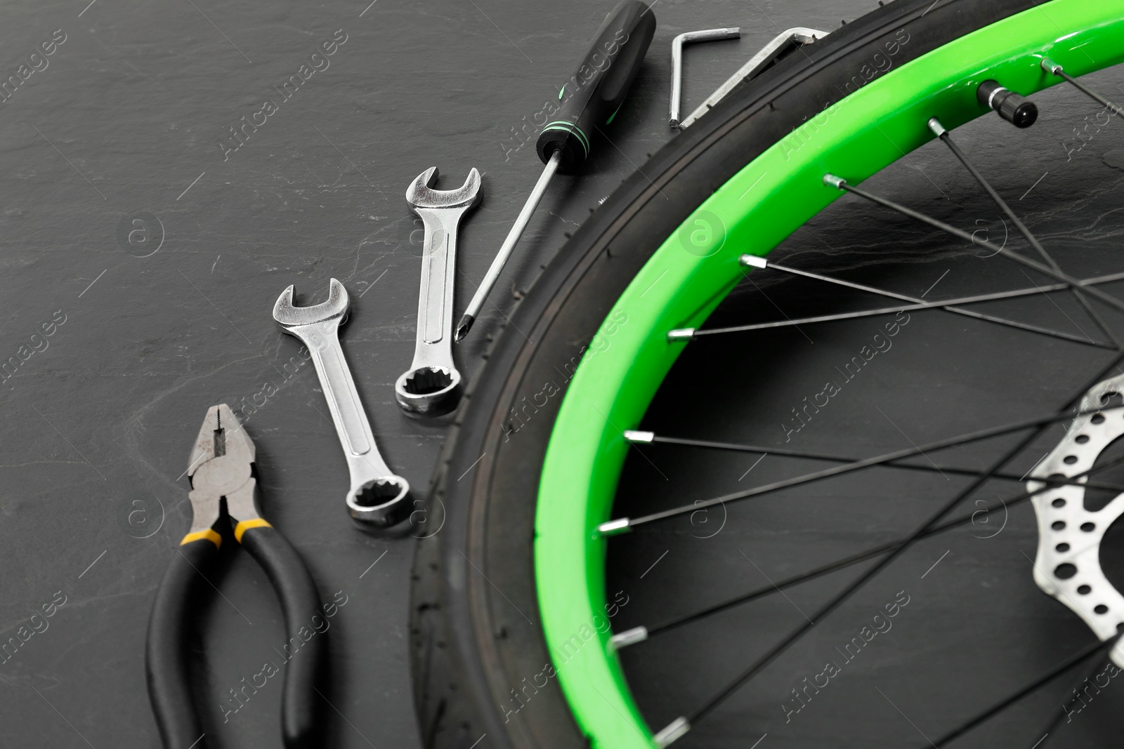 Photo of Bicycle wheel and tools on black background, closeup