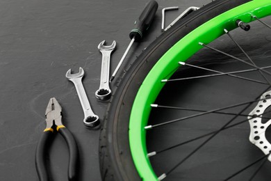 Bicycle wheel and tools on black background, closeup