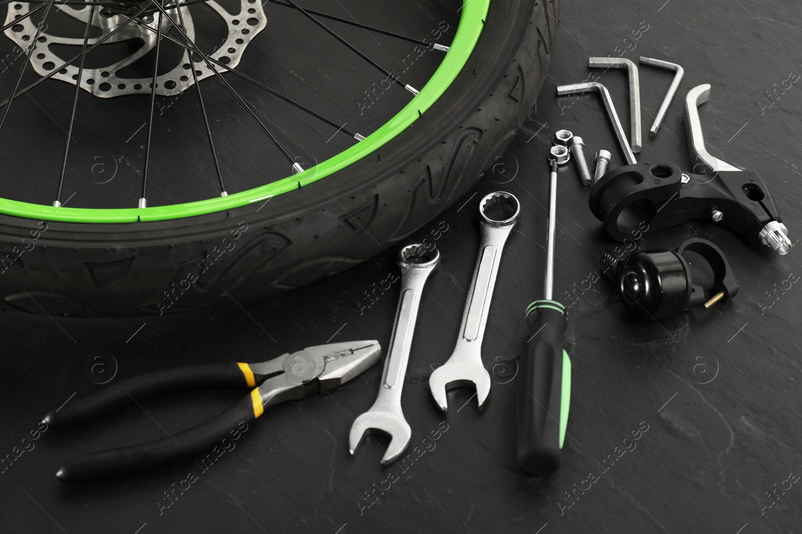 Photo of Parts of bicycle and tools on black background, closeup