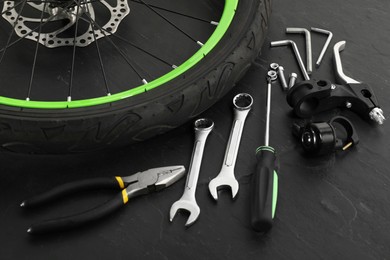 Photo of Parts of bicycle and tools on black background, closeup