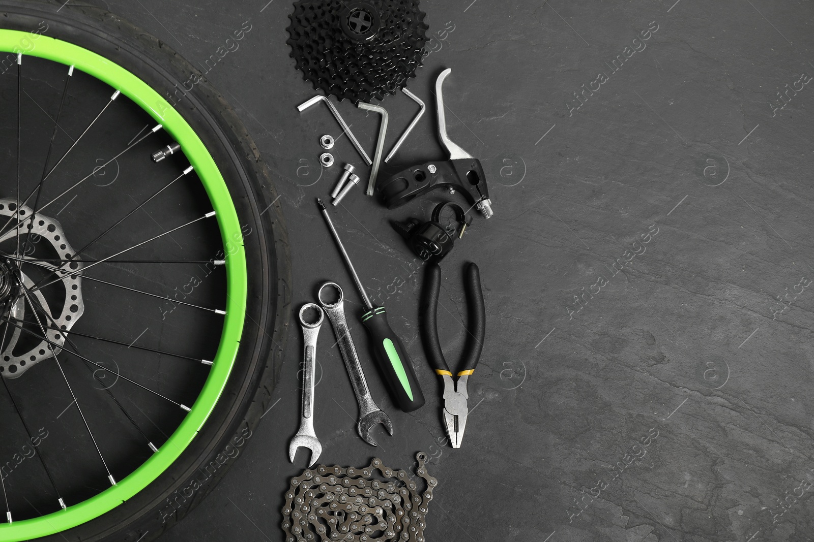 Photo of Parts of bicycle and tools on black background, flat lay. Space for text