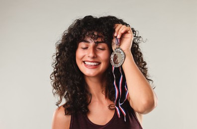 Photo of Happy winner with silver medal on light grey background