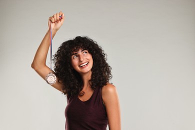 Happy winner with bronze medal on light grey background