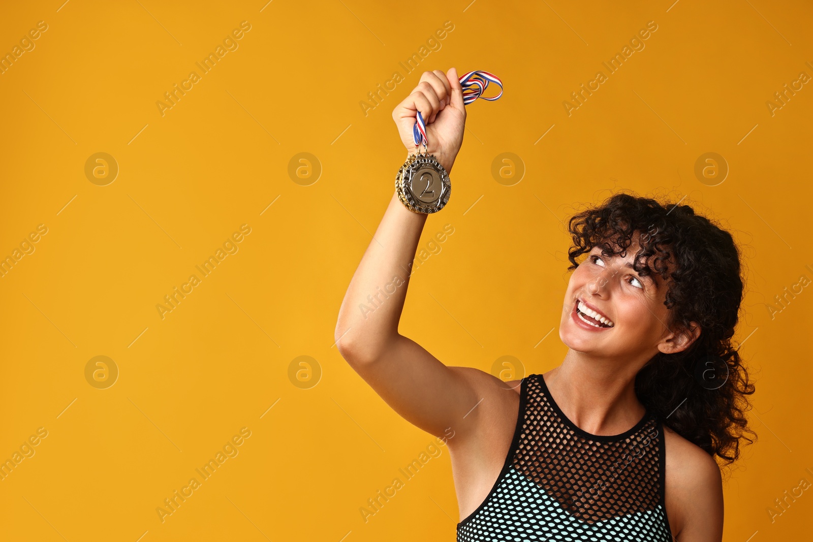 Photo of Happy winner with different medals on yellow background. Space for text