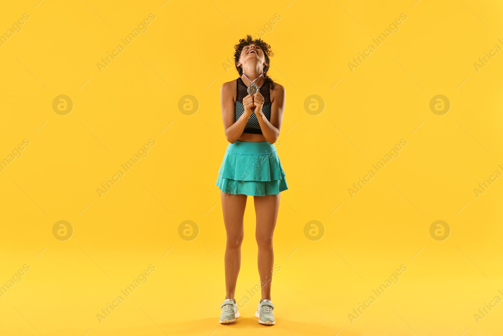 Photo of Happy winner with silver medal on yellow background