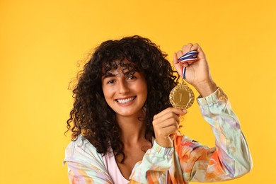 Photo of Happy winner with golden medal on yellow background