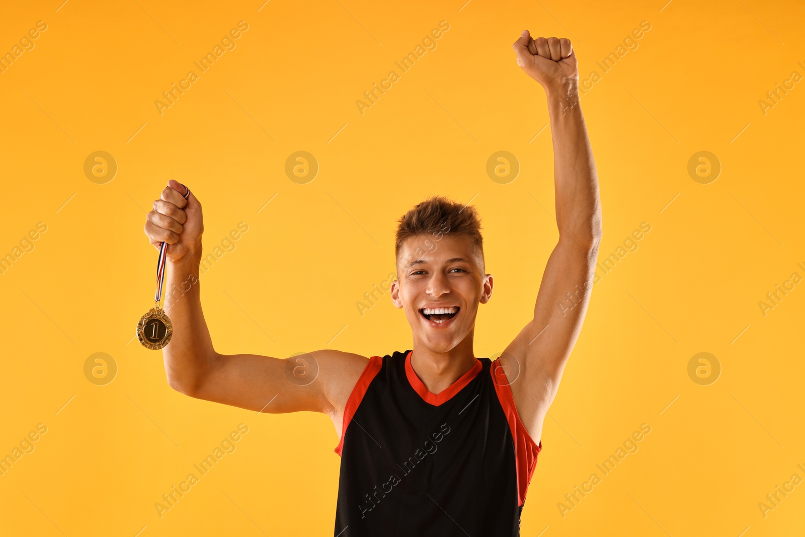 Photo of Happy winner with golden medal on yellow background