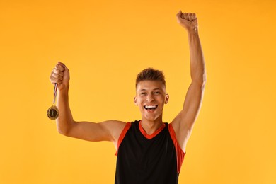 Photo of Happy winner with golden medal on yellow background