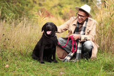 Smiling man with cute dog outdoors on autumn day