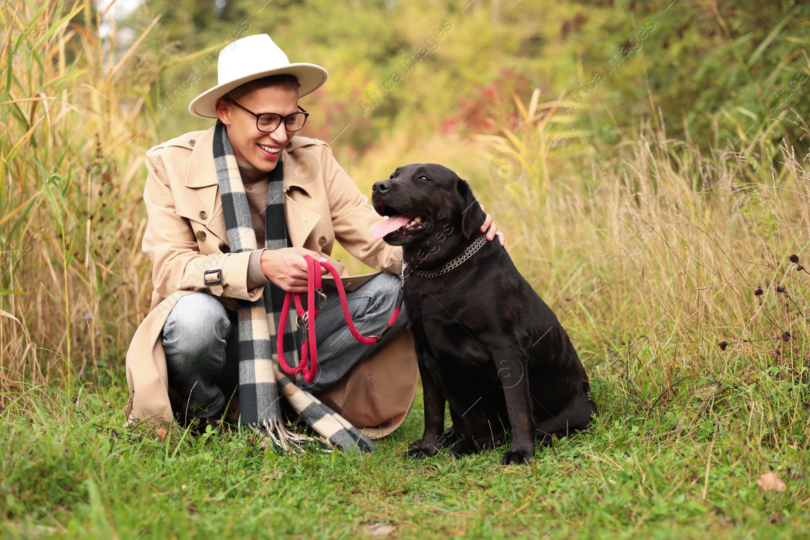 Photo of Smiling man with cute dog outdoors on autumn day