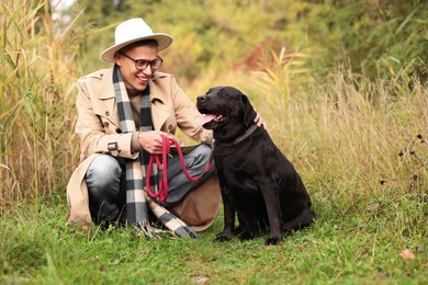 Smiling man with cute dog outdoors on autumn day