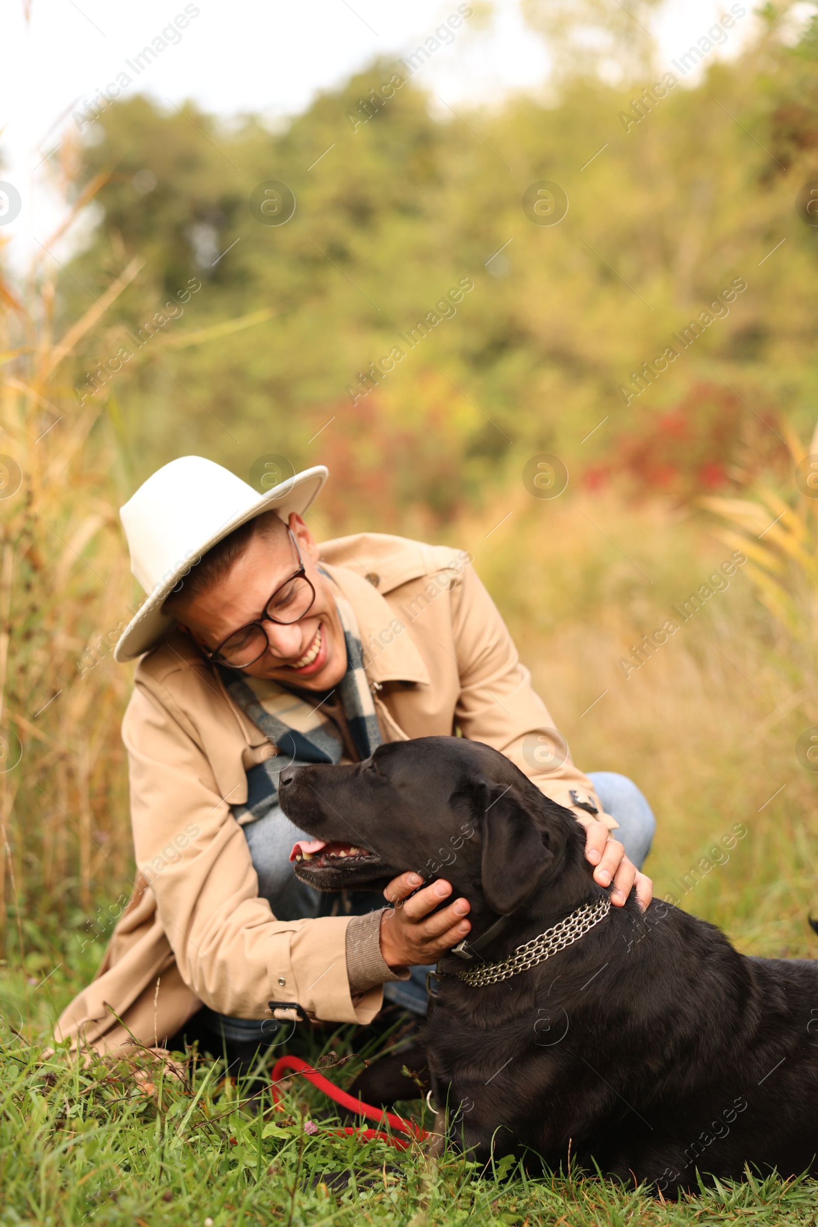 Photo of Smiling man with cute dog outdoors on autumn day