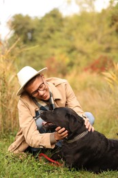 Photo of Smiling man with cute dog outdoors on autumn day