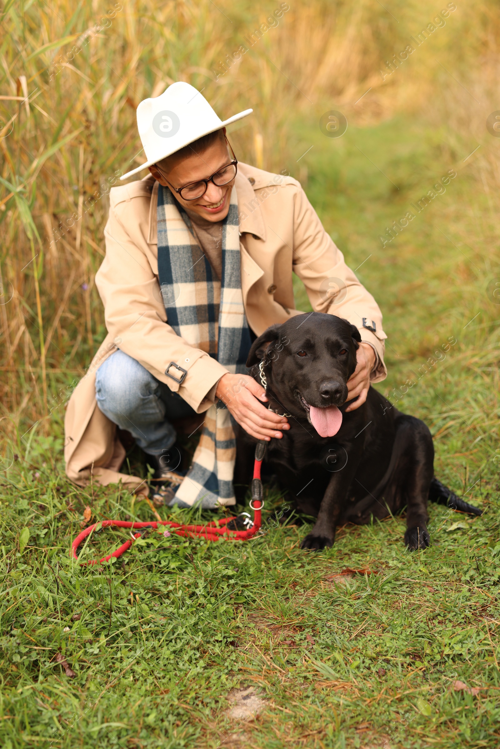 Photo of Smiling man with cute dog outdoors on autumn day