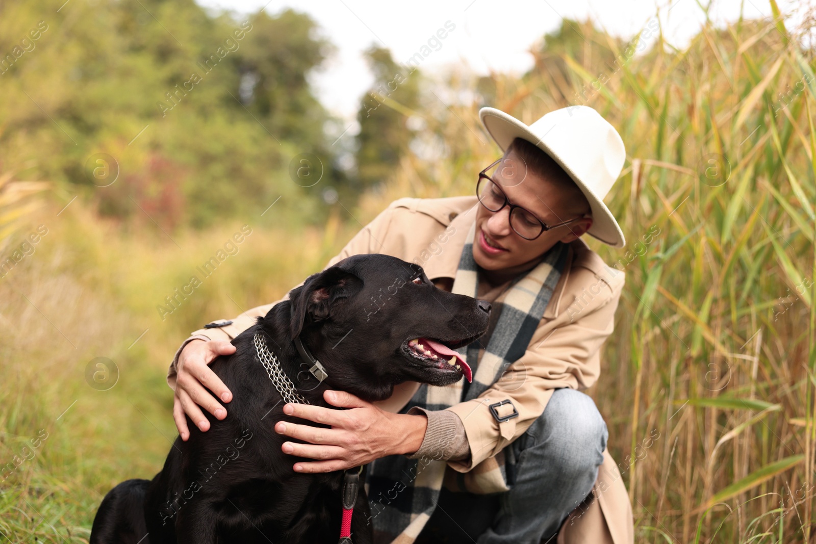 Photo of Smiling man with cute dog outdoors on autumn day