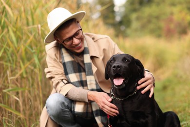 Photo of Smiling man with cute dog outdoors on autumn day