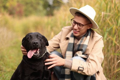 Photo of Smiling man with cute dog outdoors on autumn day