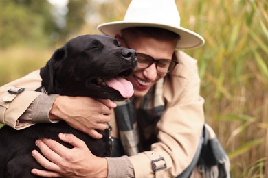 Photo of Portrait of smiling man with cute dog outdoors