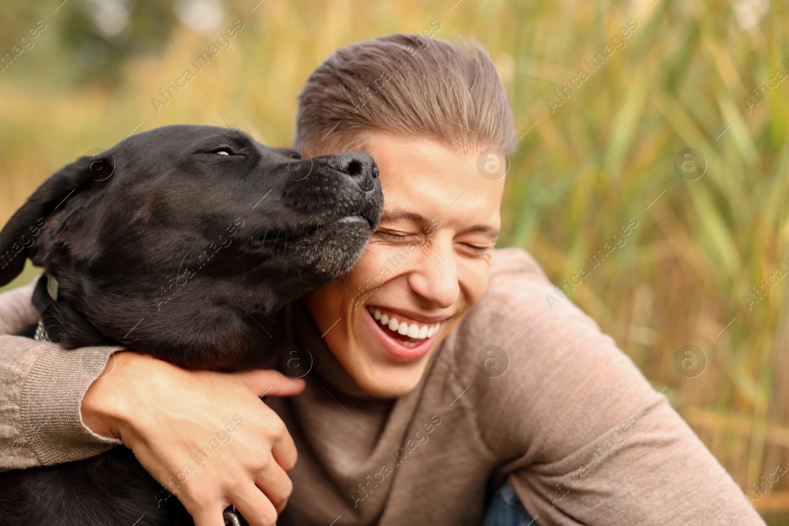 Photo of Portrait of smiling man with cute dog outdoors