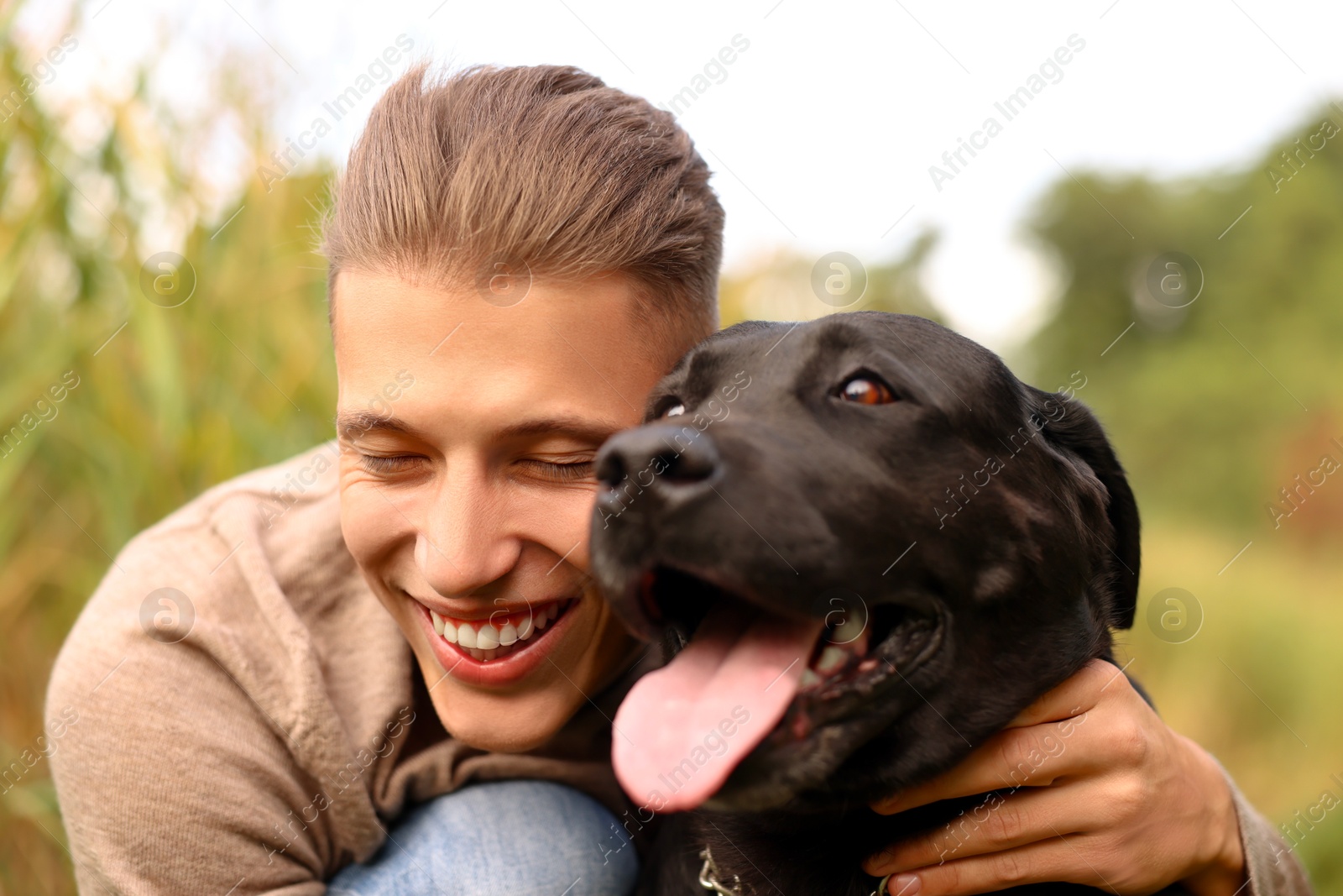 Photo of Portrait of smiling man with cute dog outdoors