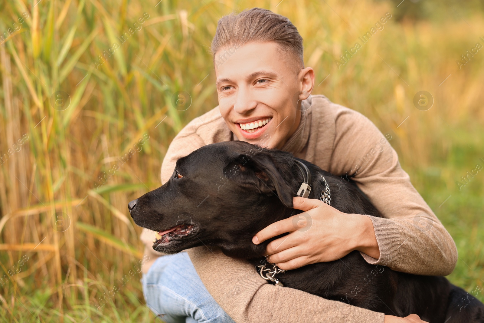 Photo of Portrait of smiling man with cute dog outdoors