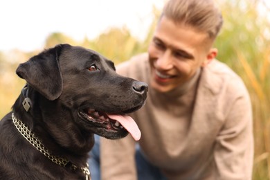 Portrait of cute dog with smiling owner outdoors, selective focus