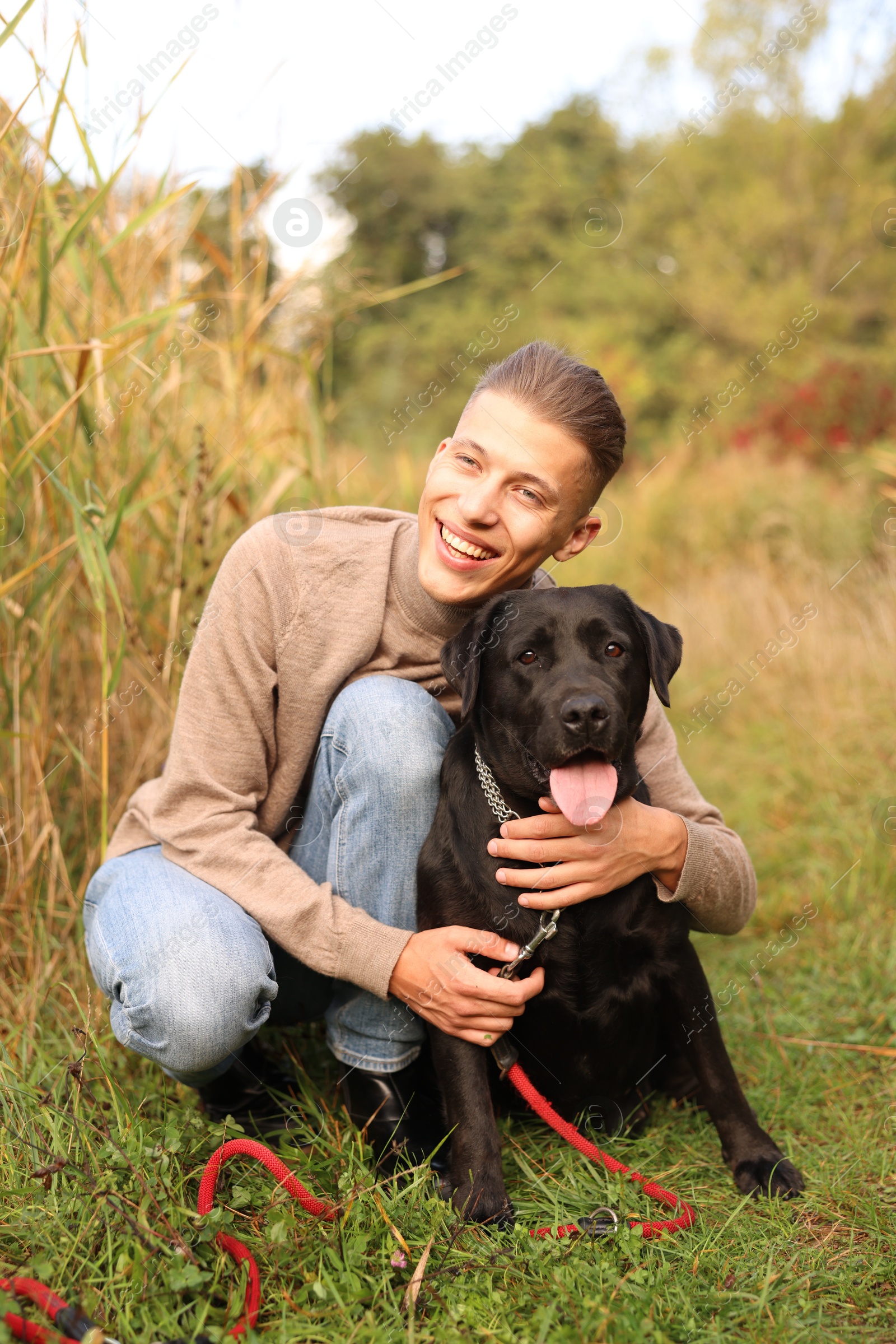 Photo of Smiling man with cute dog outdoors on autumn day