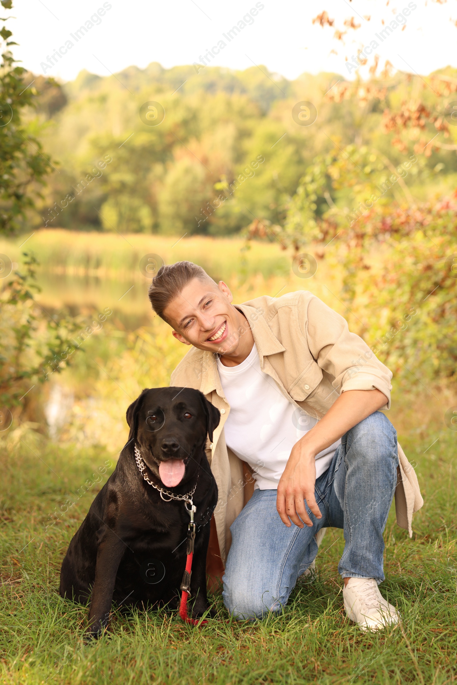 Photo of Smiling man with cute dog outdoors on autumn day