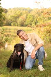 Smiling man with cute dog outdoors on autumn day