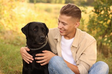 Smiling man with cute dog outdoors on autumn day