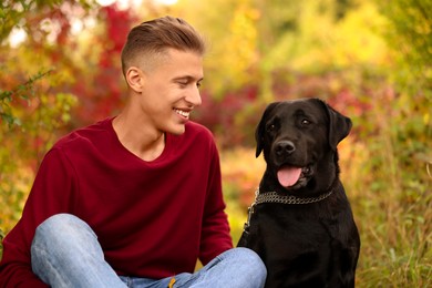 Smiling man with cute dog outdoors on autumn day